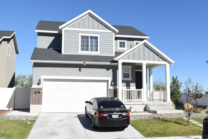 Two-story stucco and siding exterior with a dark shingle roof