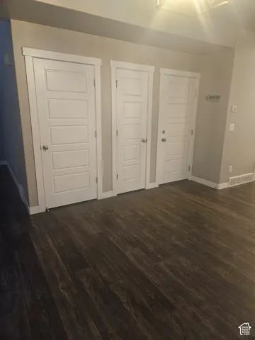 Dark wood-finish flooring with light wall tones and white trim