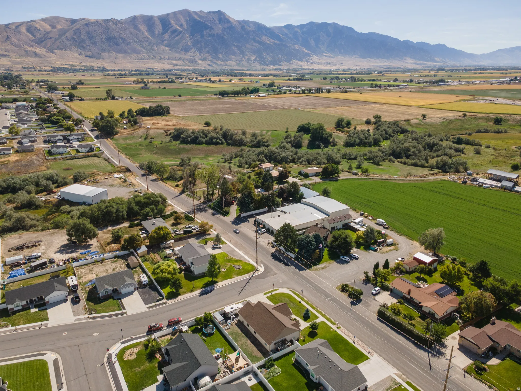 Expansive residential area with a prominent mountain backdrop, surrounded by agricultural fields