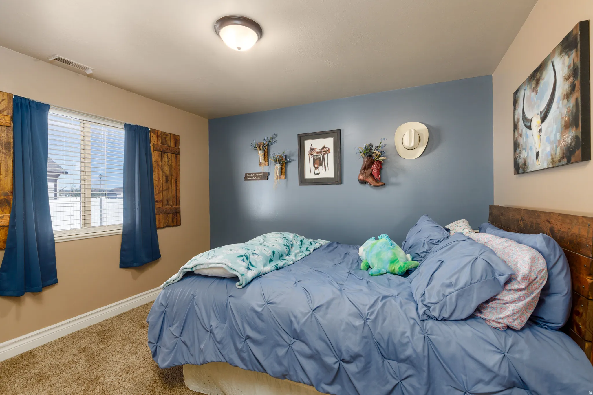 Carpeted room featuring a window with blinds and decorative wood shutters, a painted accent wall, and a flush-mount ceiling light