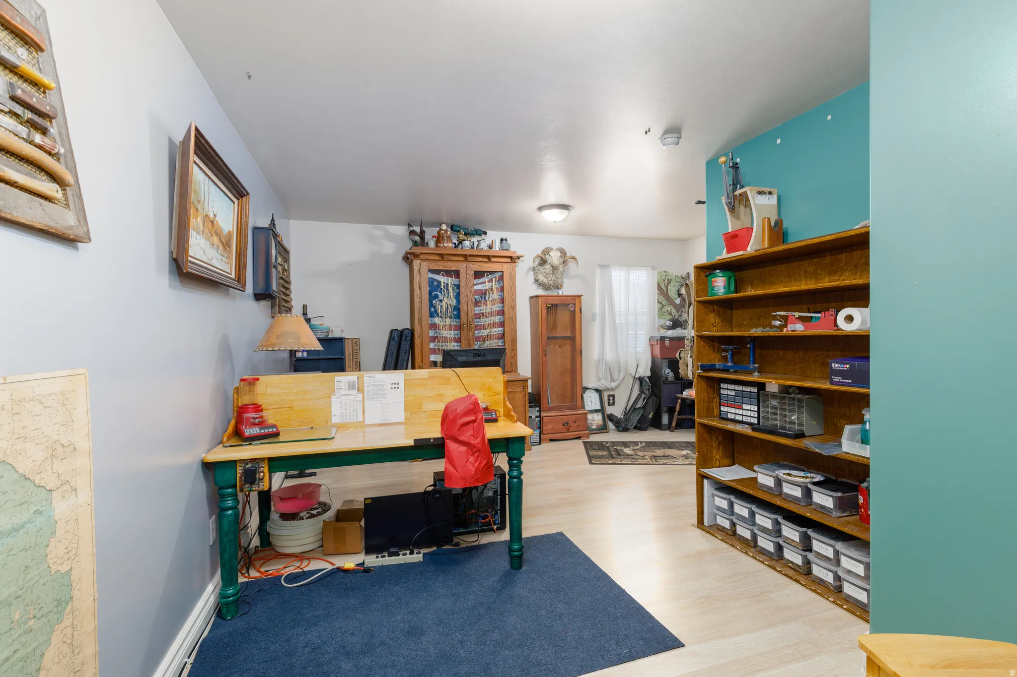 Wood-finish flooring, built-in shelving, recessed lighting, and a painted accent wall
