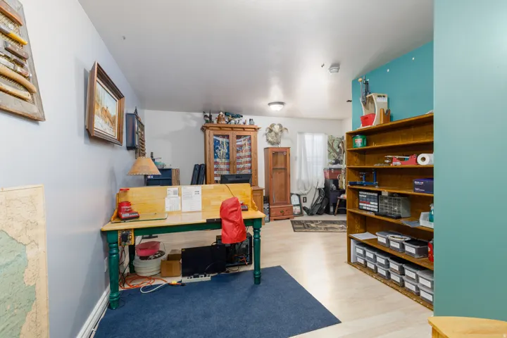 Wood-finish flooring, built-in shelving, recessed lighting, and a painted accent wall
