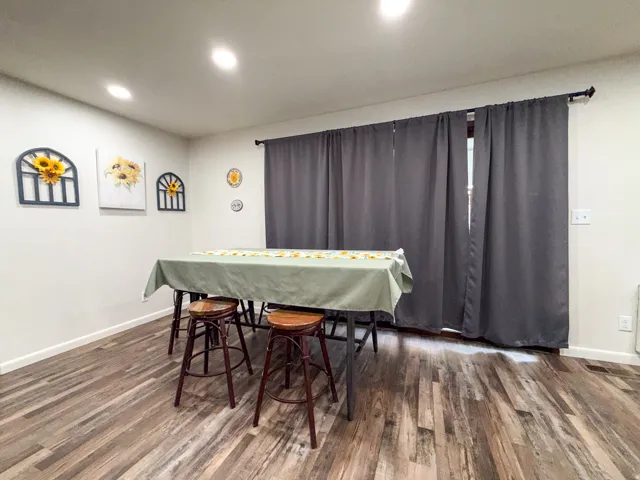 Recessed ceiling lighting, light-toned wall paint, wood-finish flooring, and a large sliding glass door