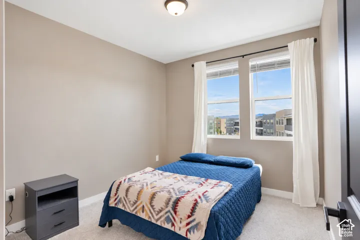 Bedroom 1 Two large windows with white frames, neutral tone walls, and overhead lighting