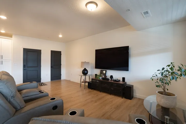 Recessed lighting, wood-finish flooring, and white walls create a bright ambiance