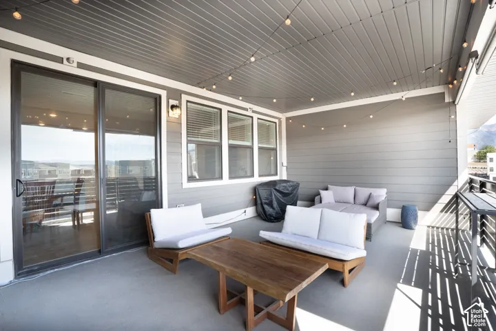 Covered balcony featuring a concrete floor, horizontal siding, and a slatted ceiling