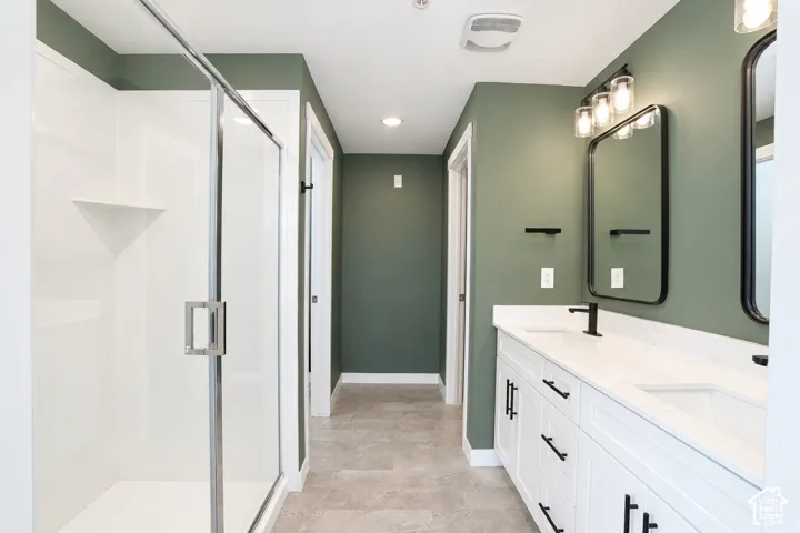 Dual vanity with white cabinetry and black hardware, white countertops, dual rectangular undermount sinks with matte black faucets, and two framed mirrors in primary bathroom