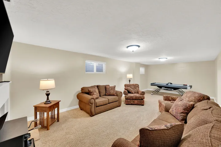 Carpeted recreation room with recessed window, painted walls, and flush-mount ceiling fixtures