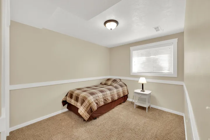 Carpeted room with a single window featuring horizontal blinds