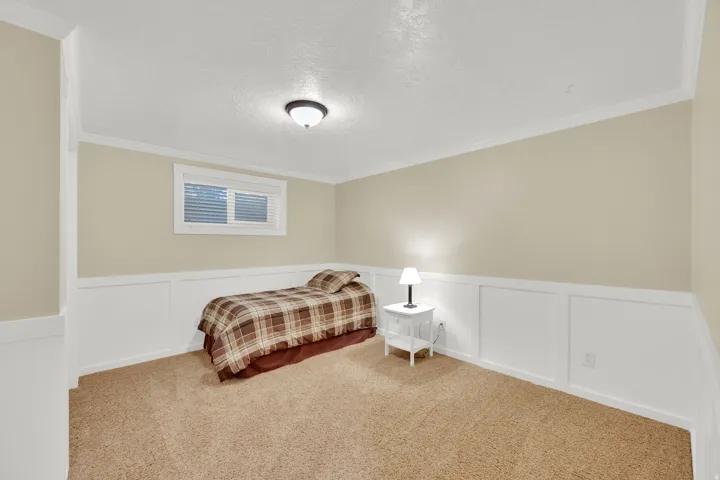 Carpeted room with wainscoting, a single window, and ceiling-mounted lighting