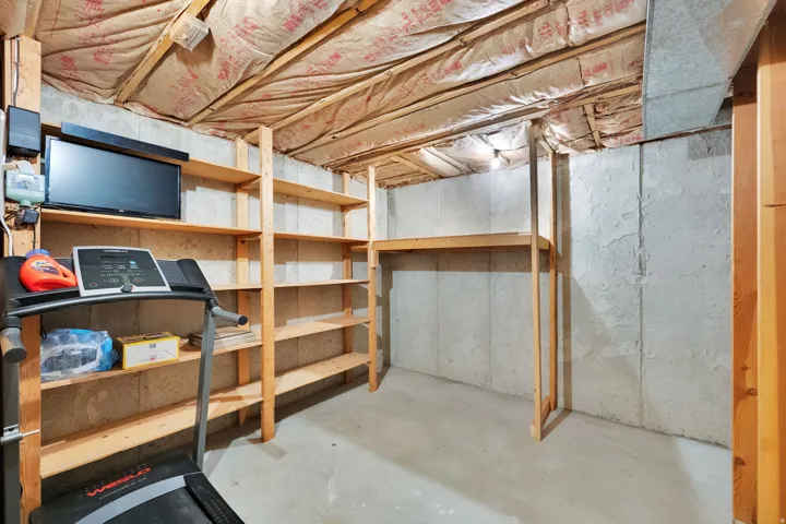 Concrete flooring, exposed ceiling joists, and wood shelving units
