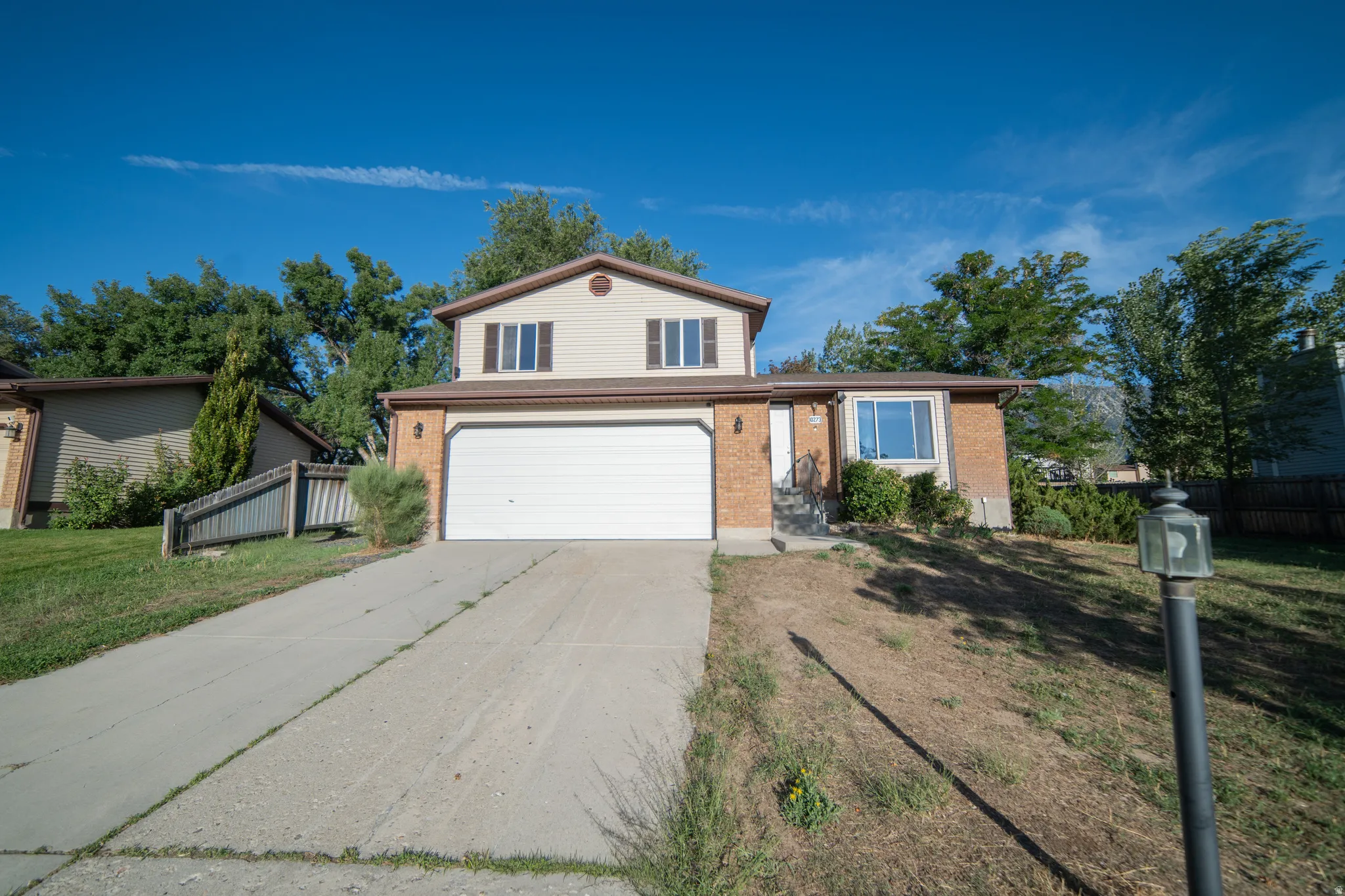 Two-story residence featuring brick and siding exterior, an attached two-car garage, and a concrete driveway