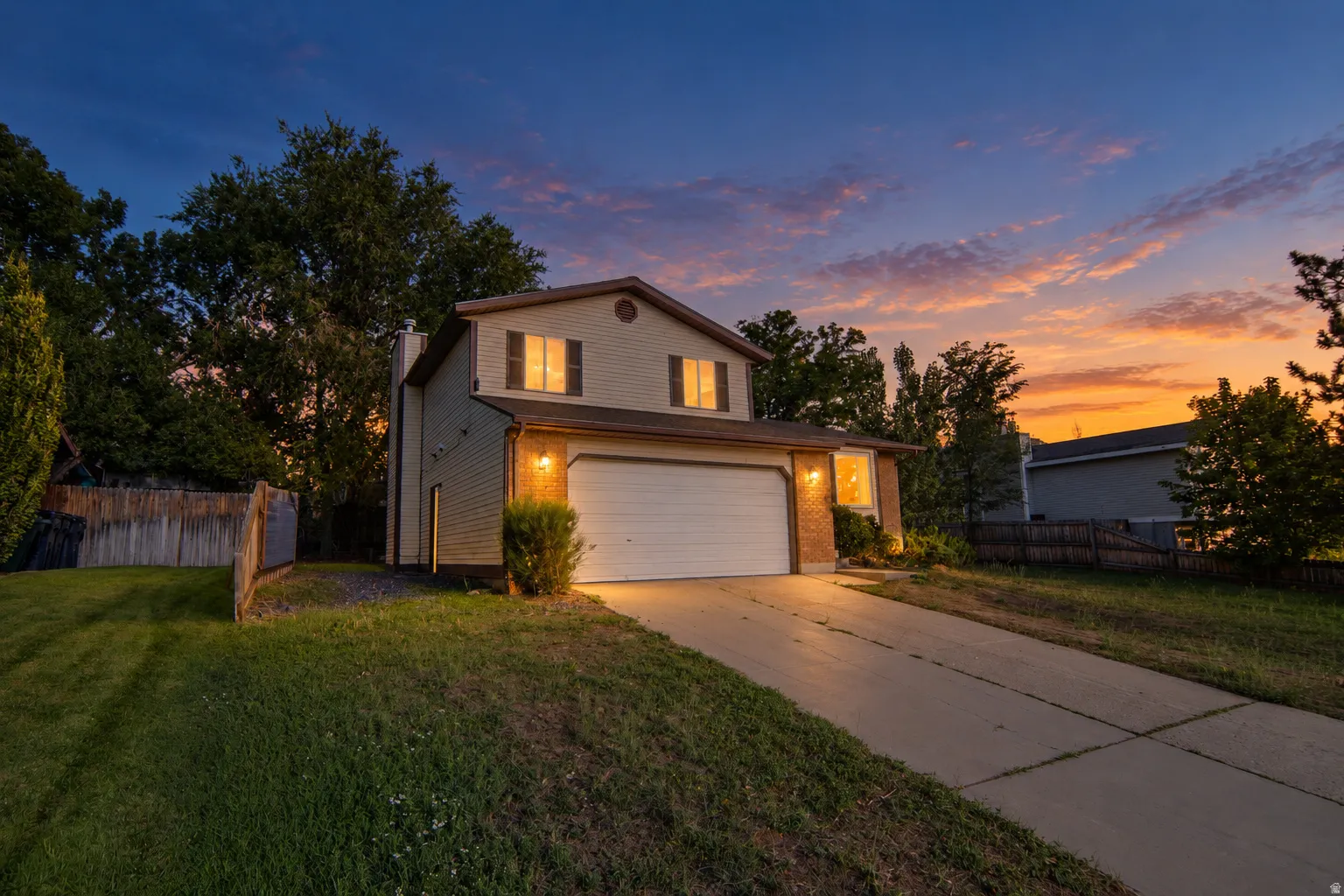 Two-story residence with siding and brick accents, an attached garage, and a concrete driveway