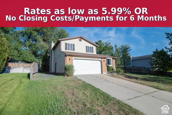 Two-story residence featuring horizontal siding, brick masonry, an attached two-car garage, concrete driveway, and wooden perimeter fencing