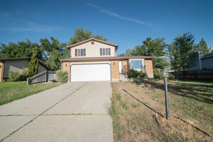 Two-story residence featuring a two-car garage, brick and siding exterior, and a concrete driveway
