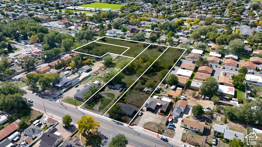 Expansive land parcel featuring multiple sections, mature trees, and direct street frontage