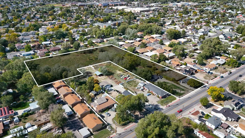 Expansive lot with varied terrain, surrounded by mature trees