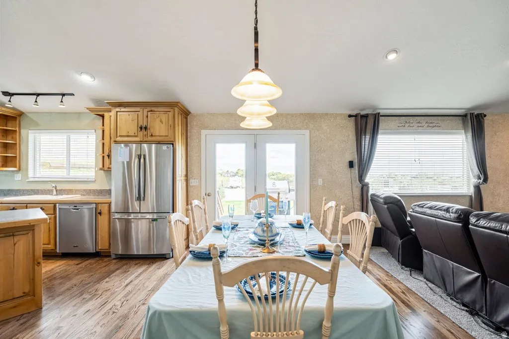 Open-concept living space with wood-finish flooring, recessed lighting, and a multi-tiered pendant light fixture