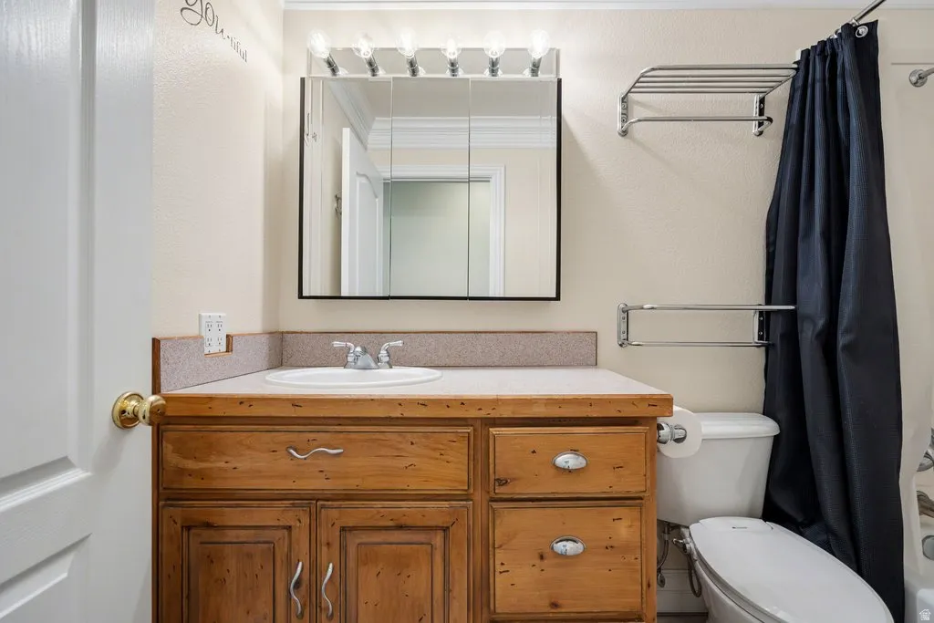 Vanity with wood-finish cabinetry, built-in sink, and laminate countertop