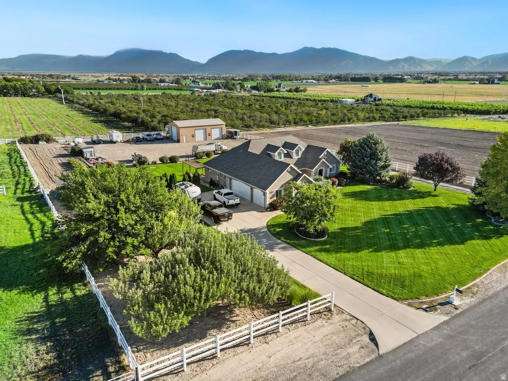 Expansive property with a large detached workshop, mature landscaping, and a mountain backdrop