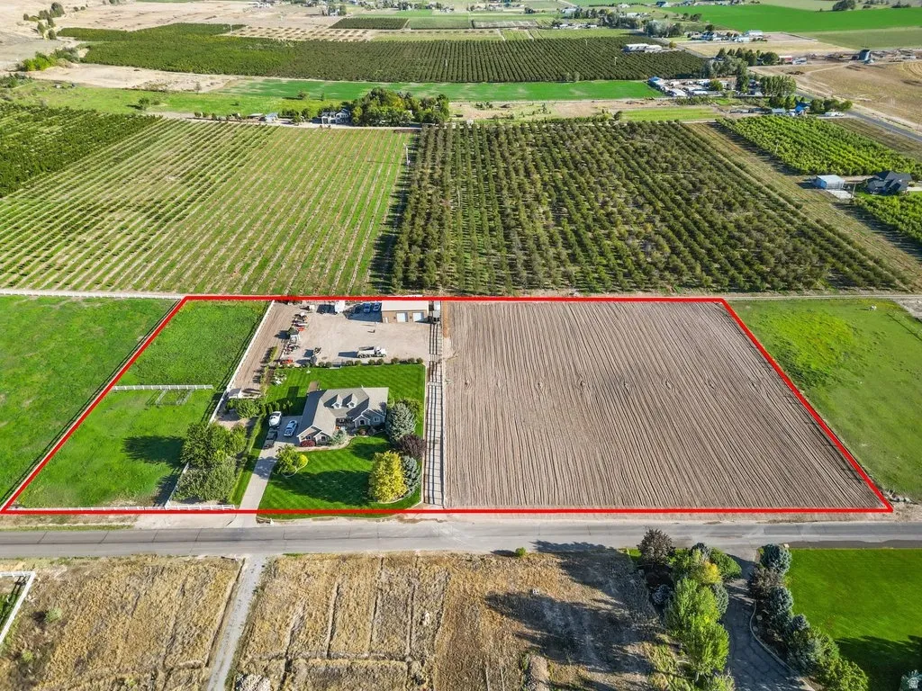 Five acres featuring a single-story residence, a large cultivated field, and a manicured lawn area