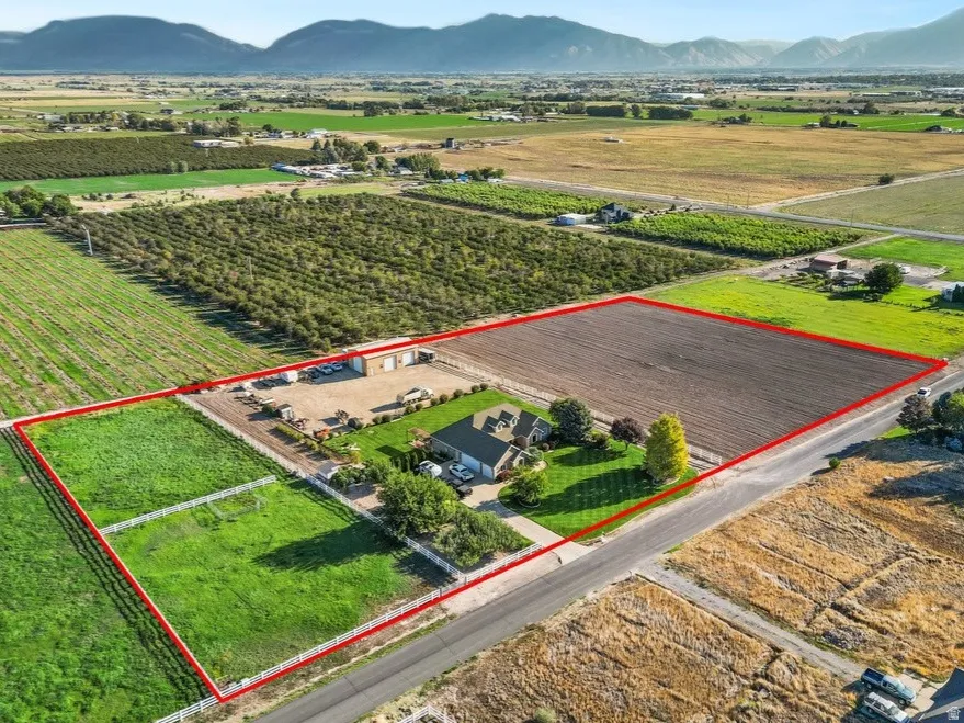 Expansive rural property featuring a primary residence, detached garage structure, and significant land area