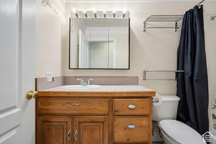 Vanity with wood-finish cabinetry, built-in sink, and laminate countertop