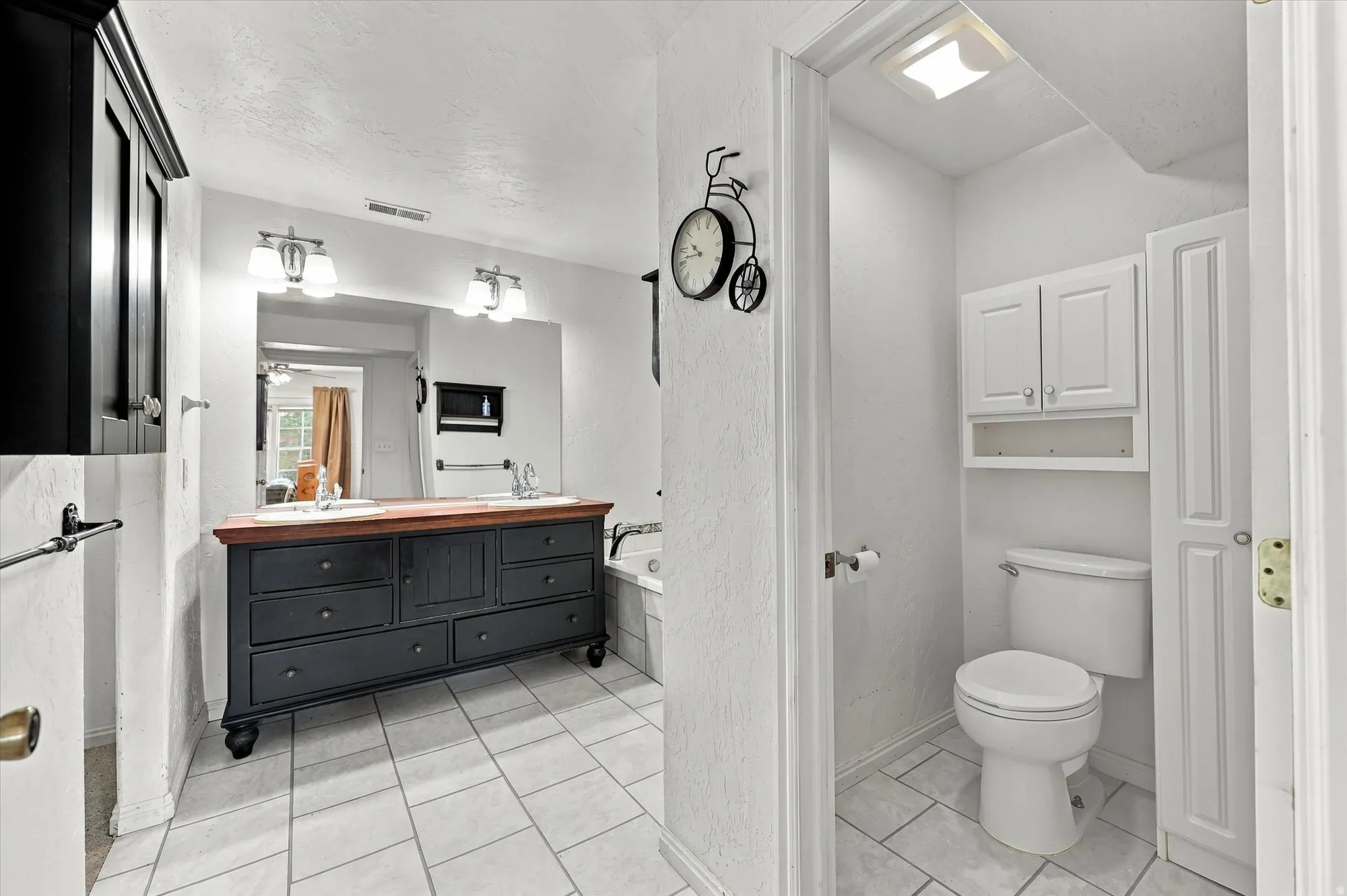 Dual vanity with undermount sinks, wood-finish countertop, and ample drawer storage