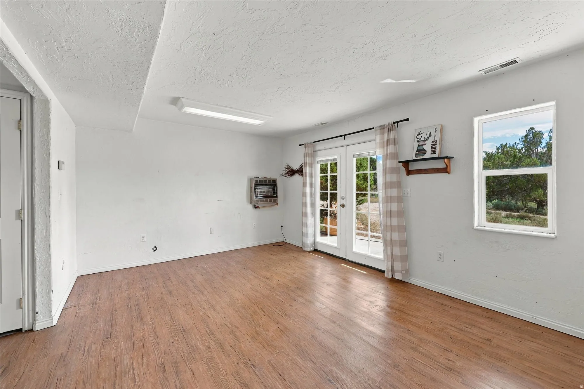 Wood-finish flooring, white walls, and a white ceiling with recessed lighting