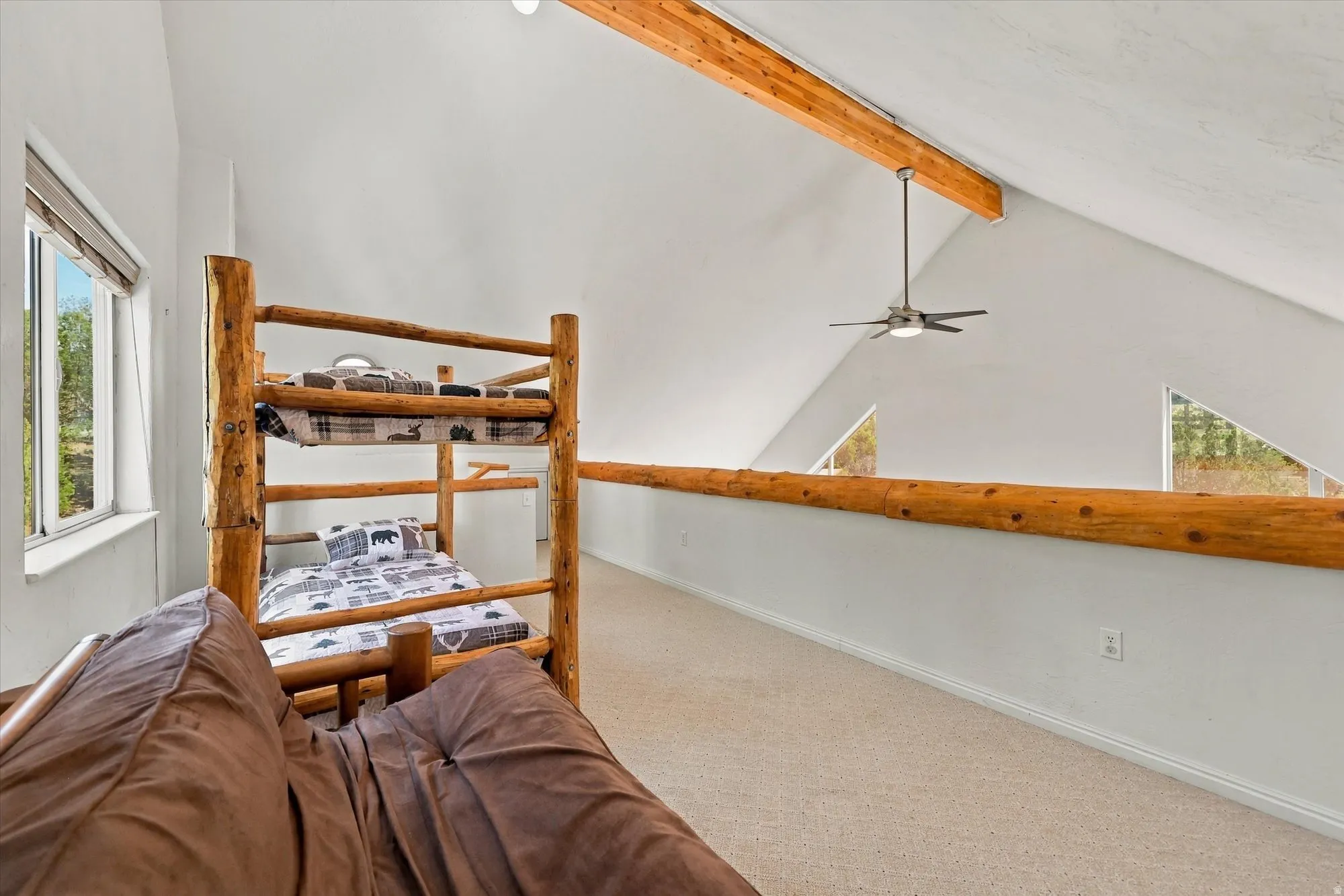Vaulted ceiling with exposed wood beams and ceiling fan, white walls, and light-colored carpeting