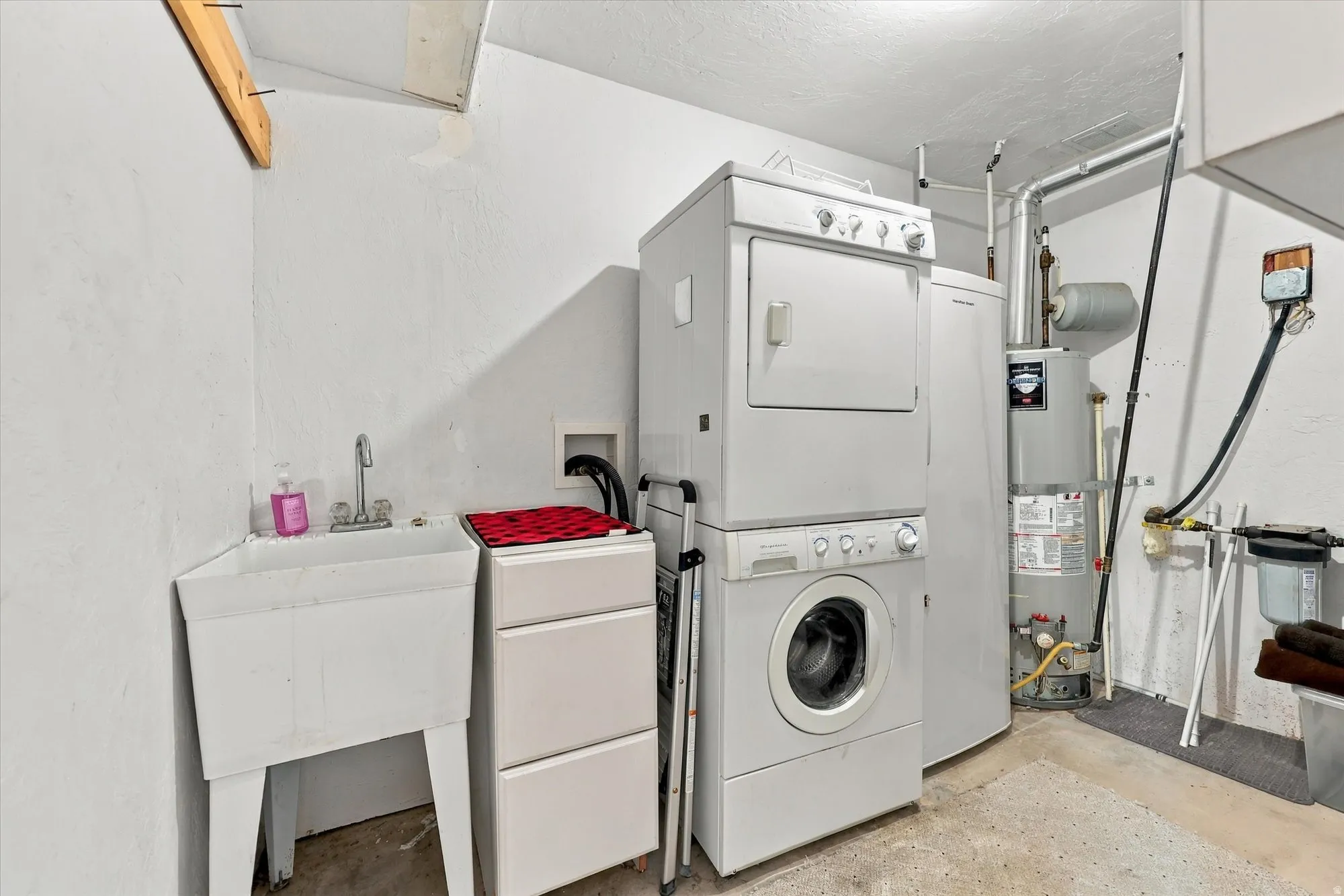 Dedicated laundry area featuring a utility sink and water heater