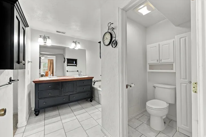 Dual vanity with undermount sinks, wood-finish countertop, and ample drawer storage