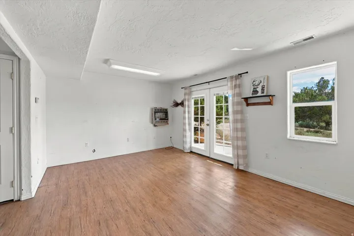 Wood-finish flooring, white walls, and a white ceiling with recessed lighting