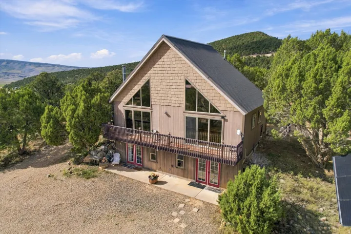 Cabin with a walkout basement, a full-width balcony, and a metal roof