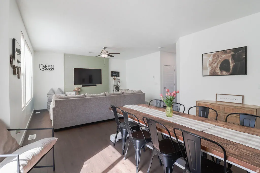 Dark wood-finish flooring throughout, bright white walls, recessed lighting, and a ceiling fan with integrated light
