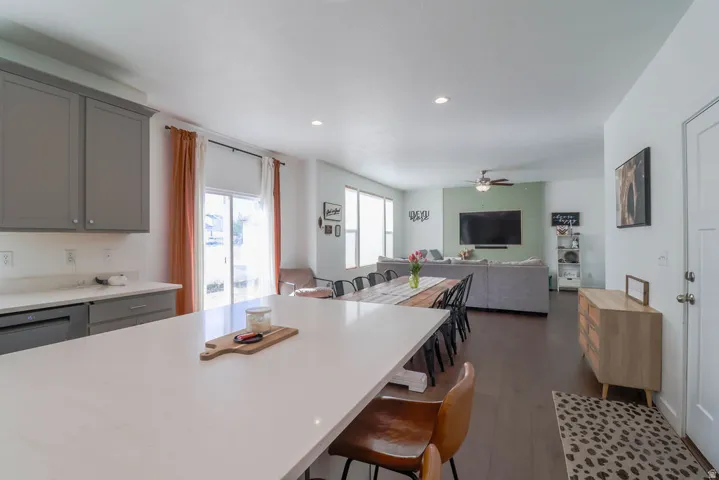 Expansive kitchen island with a light-toned countertop, gray cabinetry, and a sliding glass door