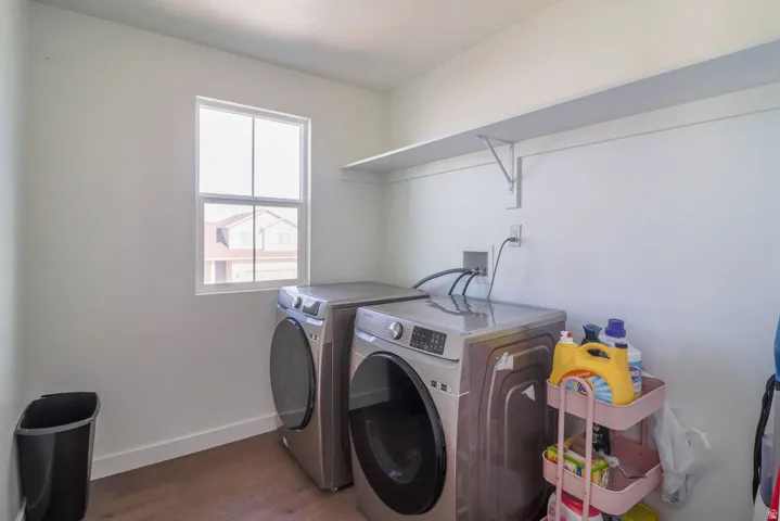 Laundry area featuring wood-finish flooring, a single window, and an integrated wall shelf