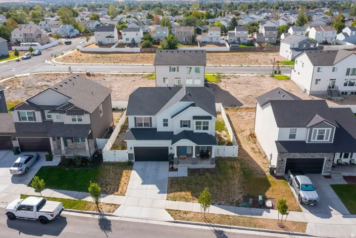 Two-story residence with a dark gray roof, light siding, and an attached two-car garage