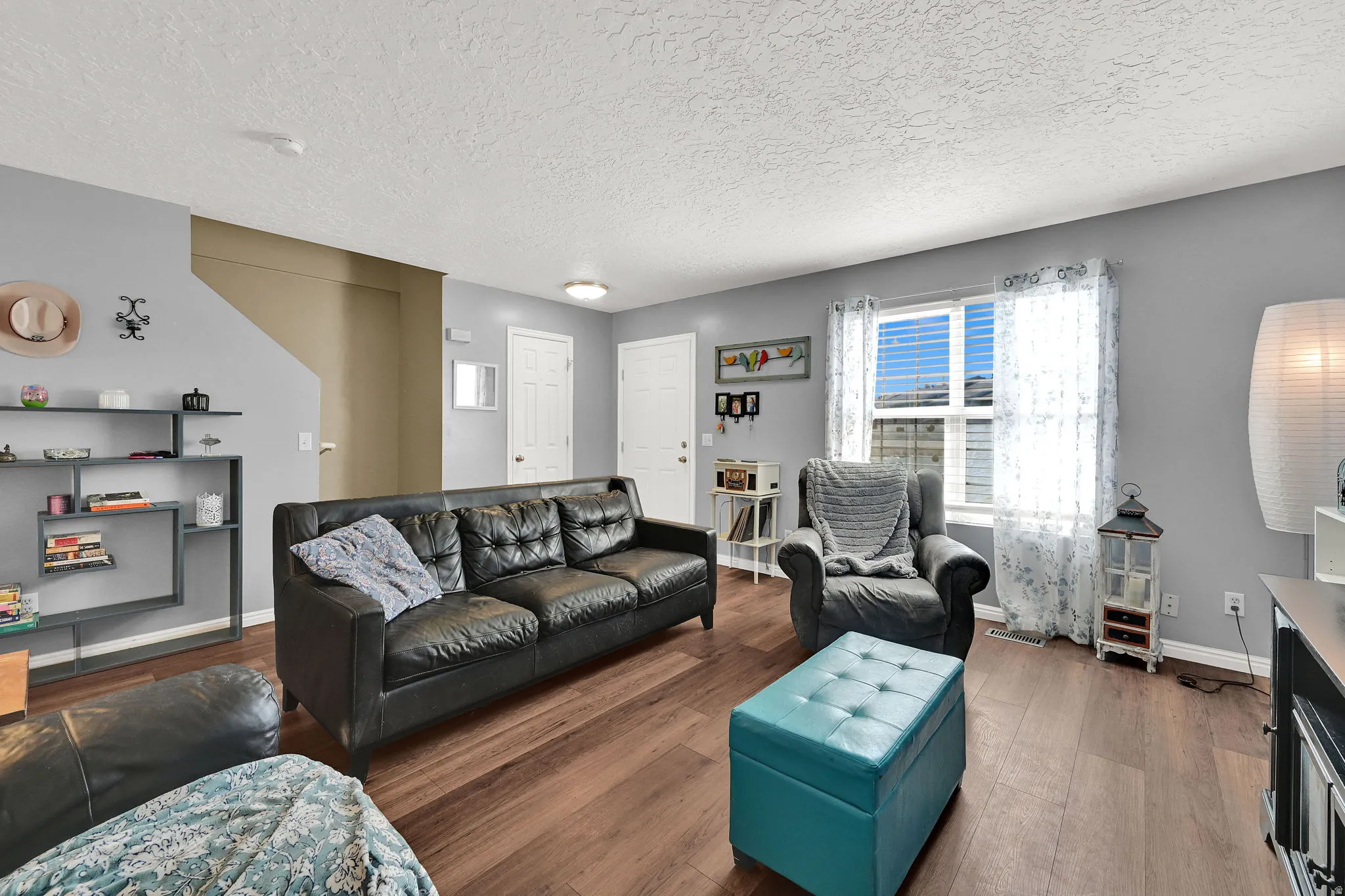 Wood-finish flooring, light gray wall paint, and white trim throughout