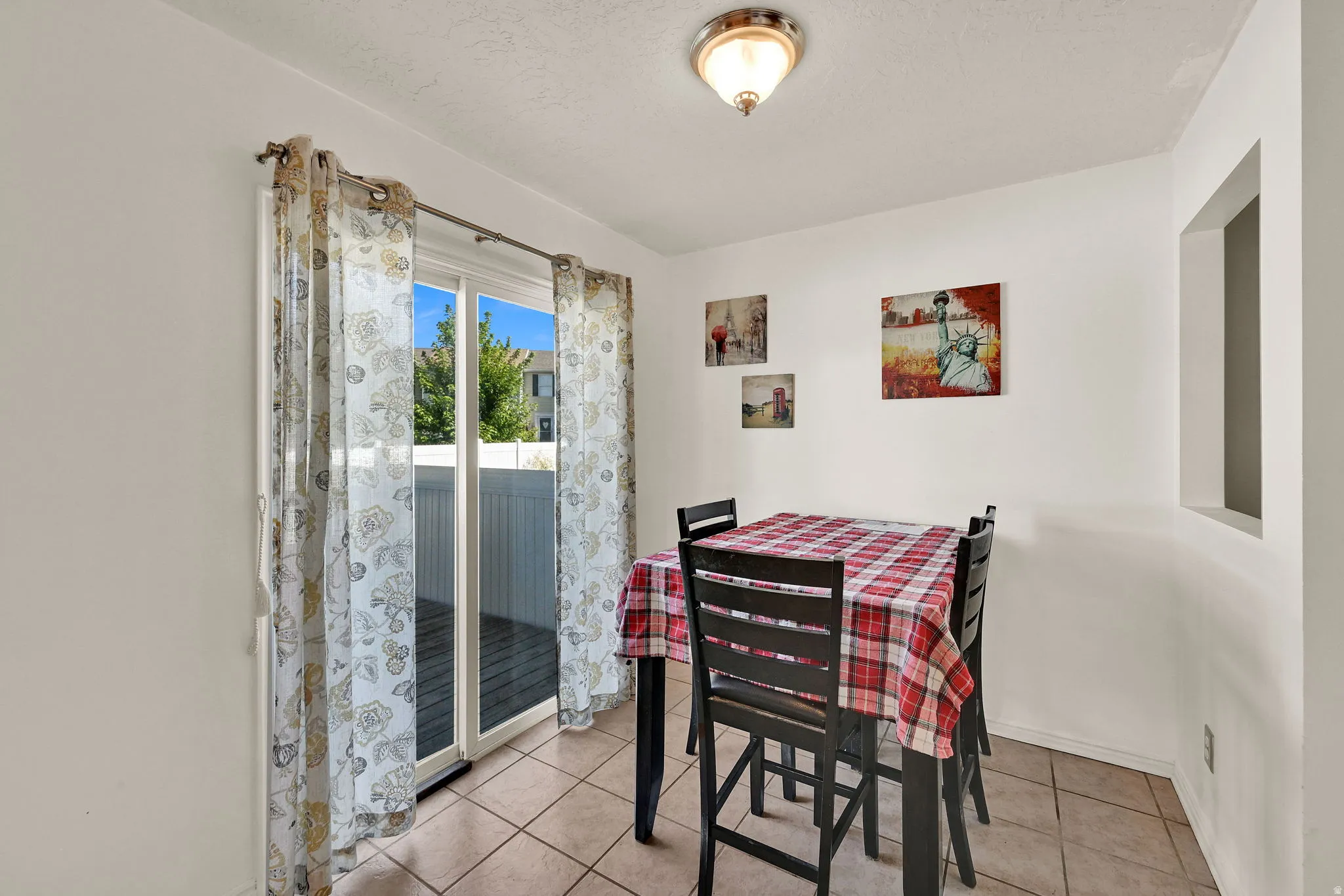Sliding glass door, recessed wall opening, ceiling-mounted light fixture, tile flooring