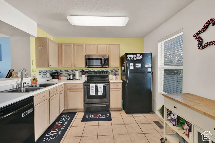 Kitchen featuring wood-finish cabinetry, tile flooring, and a window with blinds