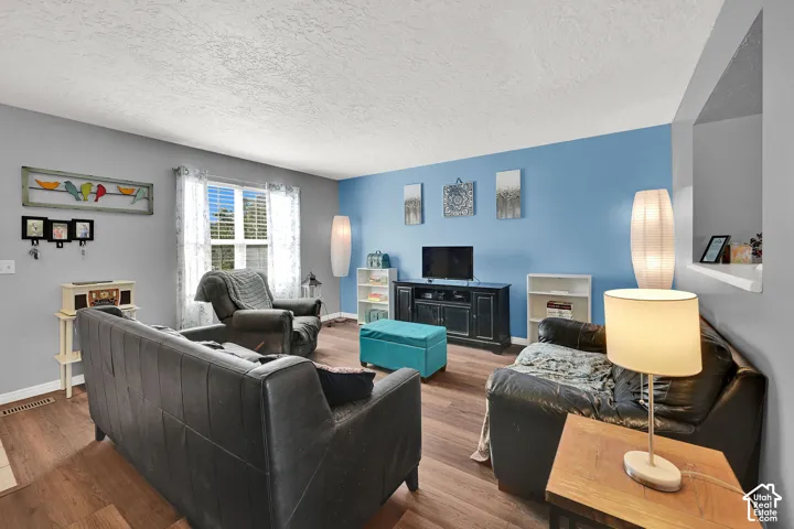 Wood-finish flooring throughout, a large window with horizontal blinds, and a built-in display niche