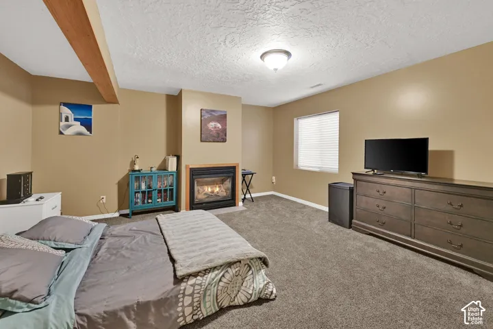 Built-in fireplace with a hearth, wood-finish ceiling beam, window with blinds, and recessed lighting