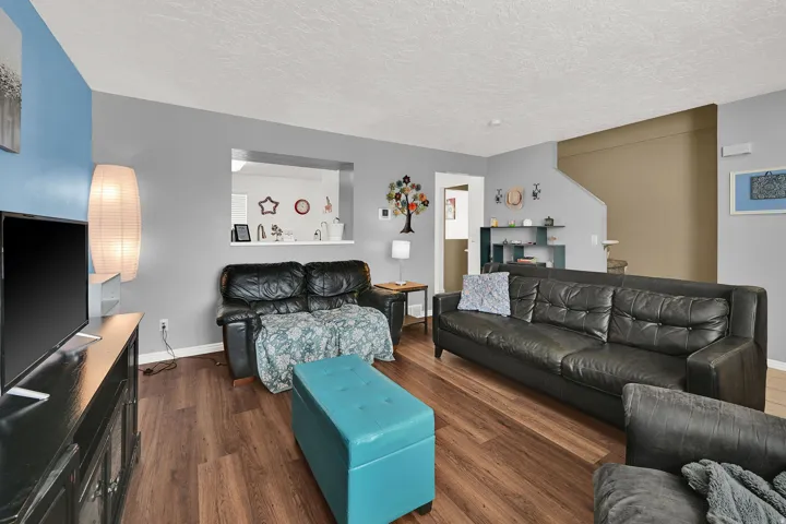 Wood-finish flooring throughout, with a pass-through window to the kitchen