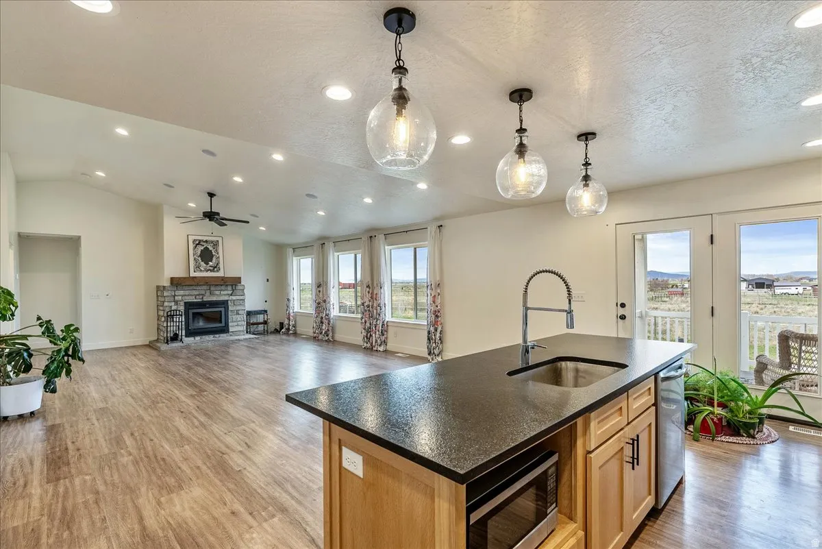 Open-concept living area with wood-finish flooring, recessed lighting, and vaulted ceilings