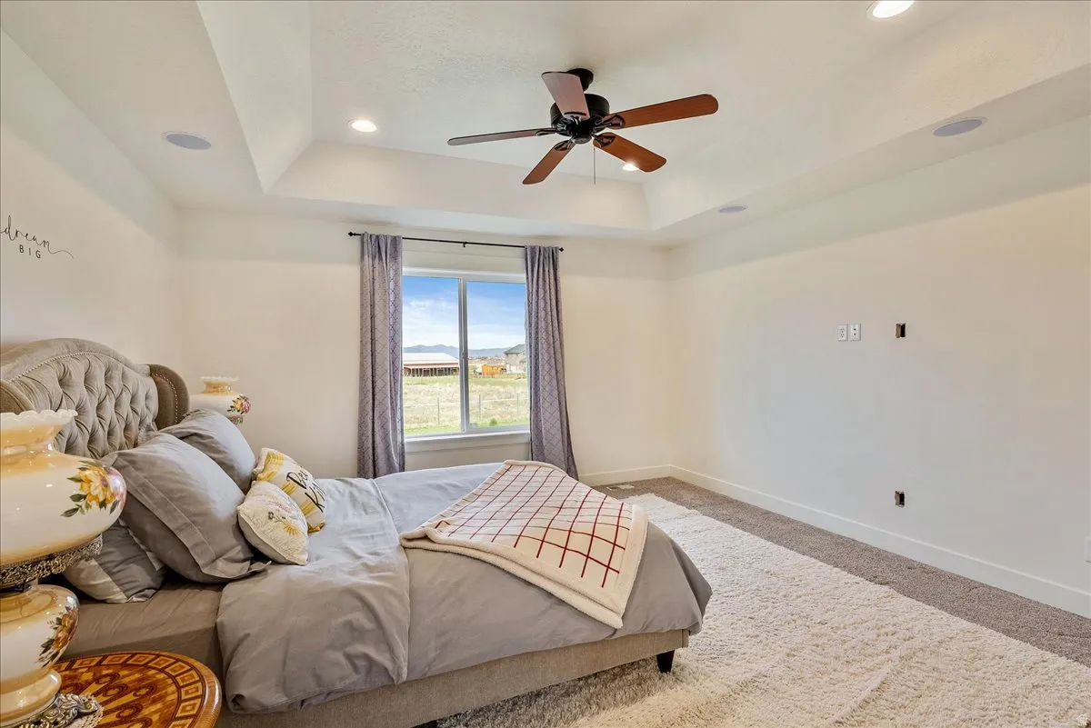 Tray ceiling with recessed lighting, ceiling fan, and built-in speakers