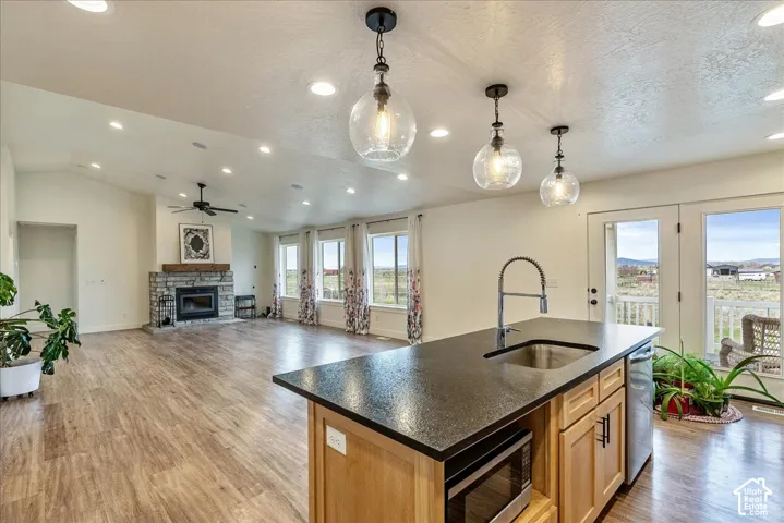 Open-concept living area with wood-finish flooring, recessed lighting, and vaulted ceilings