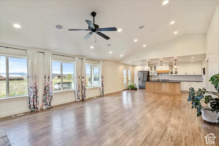 Vaulted ceilings, recessed lighting, and wood-finish flooring characterize this open-concept space