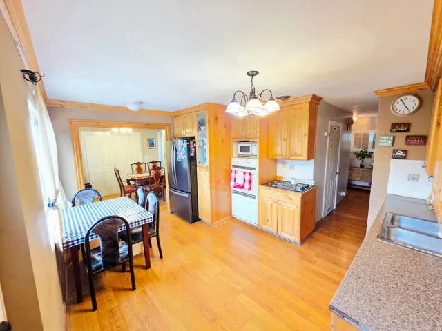 Kitchen featuring wood-finish flooring, recessed lighting, wood cabinetry, and a double basin sink with countertop space