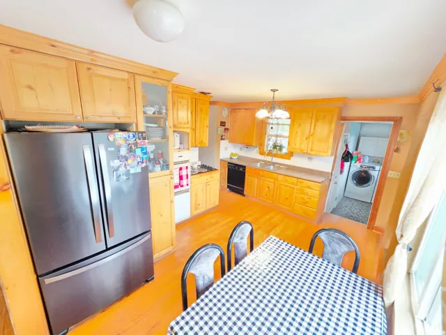 Kitchen featuring wood-finish cabinetry, stainless steel refrigerator, and recessed sink